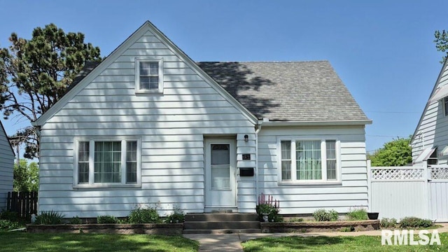 view of front of home with fence and roof with shingles