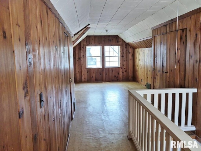 additional living space featuring wood walls, vaulted ceiling, and carpet