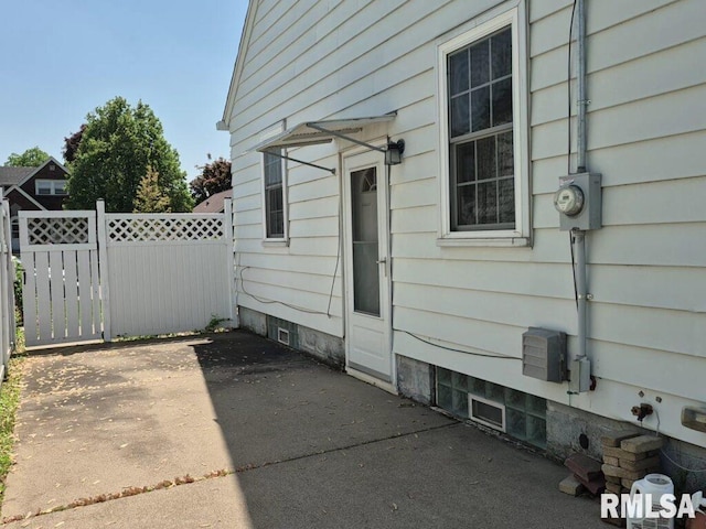 view of side of home with a patio area and fence