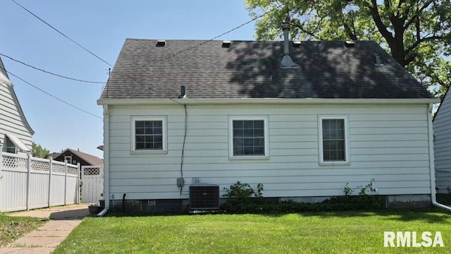 rear view of property featuring central AC unit and roof with shingles