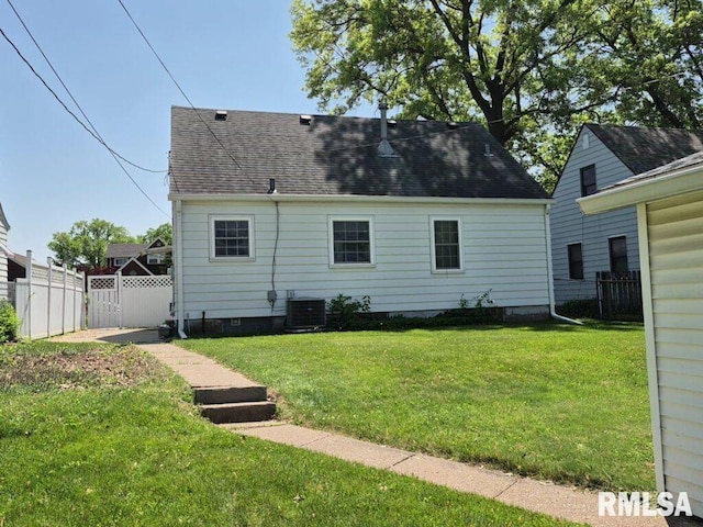 rear view of house featuring cooling unit and a shingled roof