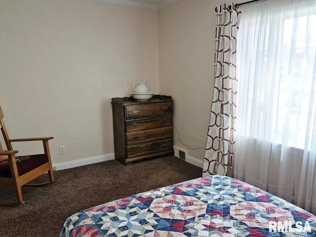 carpeted bedroom featuring crown molding and baseboards