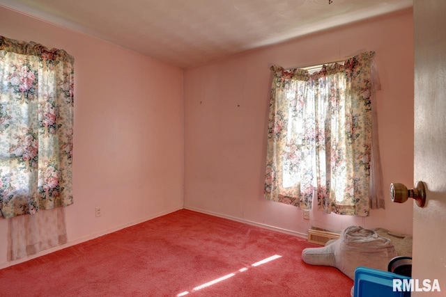 empty room featuring carpet and baseboards