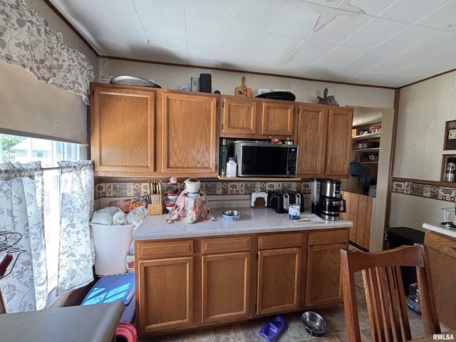 451 S Grove St, Kewanee, IL 61443 - kitchen with wallpapered walls, light countertops, brown cabinets, and ornamental molding