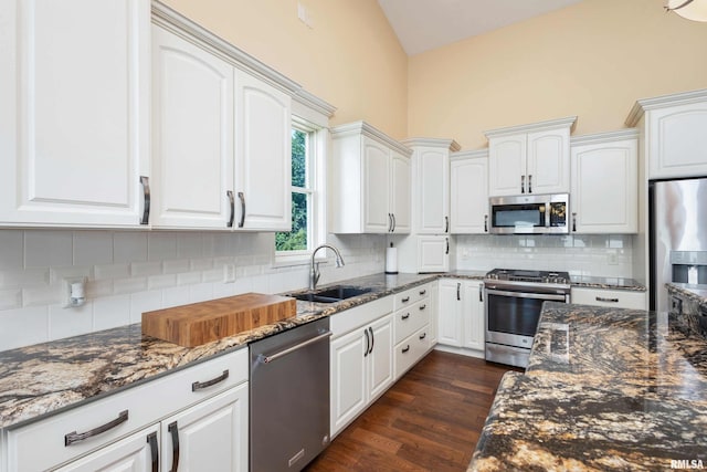24711 178th St, Pleasant Valley, IA 52767 - kitchen with appliances with stainless steel finishes, dark stone countertops, a sink, white cabinets, and dark wood-type flooring