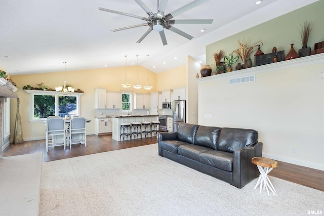 24711 178th St, Pleasant Valley, IA 52767 - living room with a ceiling fan, a chandelier, dark wood-type flooring, baseboards, and high vaulted ceiling