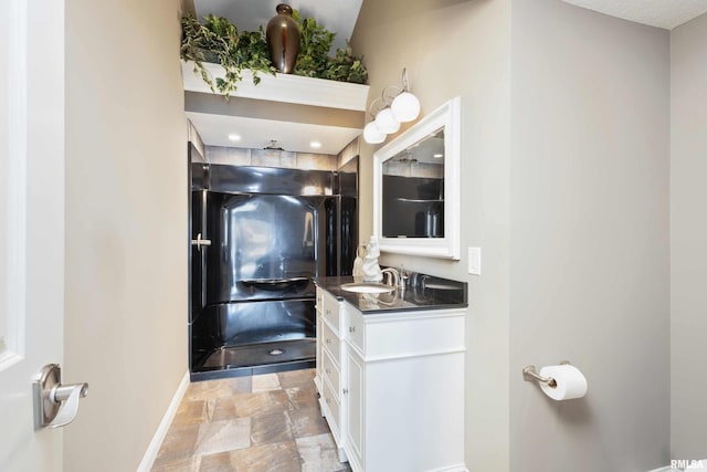 24711 178th St, Pleasant Valley, IA 52767 - full bathroom with baseboards, vanity, stone finish flooring, and a shower