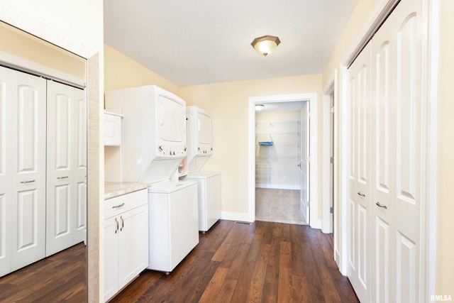 24711 178th St, Pleasant Valley, IA 52767 - laundry room with stacked washer / dryer, dark wood-type flooring, baseboards, and cabinet space