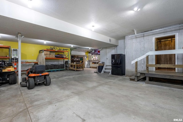 24711 178th St, Pleasant Valley, IA 52767 - garage with a workshop area and black fridge