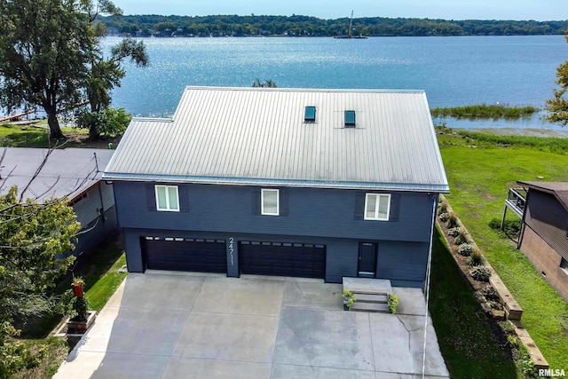 24711 178th St, Pleasant Valley, IA 52767 - view of front of property with driveway, a water view, a garage, and metal roof
