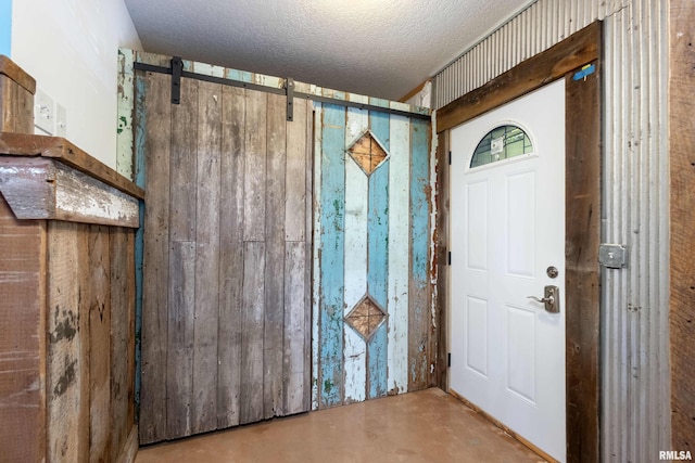 24711 178th St, Pleasant Valley, IA 52767 - entrance foyer featuring finished concrete flooring, a textured ceiling, and a barn door