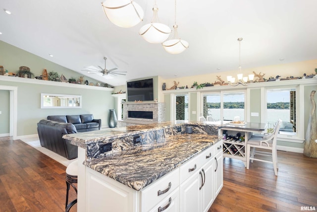 24711 178th St, Pleasant Valley, IA 52767 - kitchen with a chandelier, a fireplace, ceiling fan, dark wood-style floors, and dark stone counters