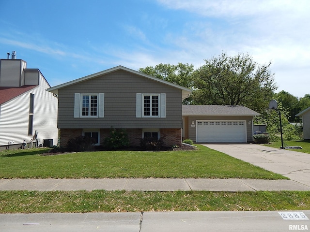 split level home featuring driveway, a front yard, an attached garage, cooling unit, and brick siding