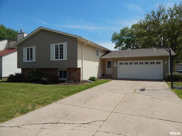 split level home with an attached garage, concrete driveway, a front yard, and brick siding