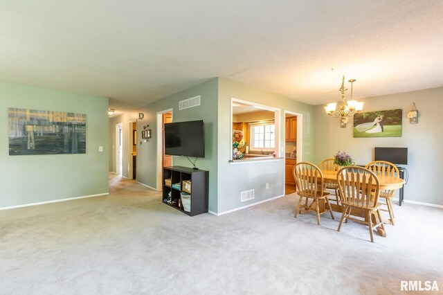 2885 Willow Dr, Bettendorf, IA 52722 - dining space with a chandelier, baseboards, and light carpet