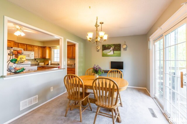 2885 Willow Dr, Bettendorf, IA 52722 - dining room with healthy amount of natural light, baseboards, a chandelier, and light colored carpet