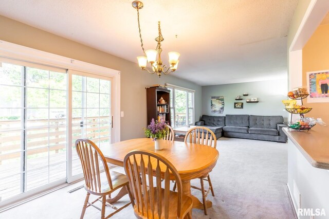 2885 Willow Dr, Bettendorf, IA 52722 - dining area featuring a chandelier and light colored carpet