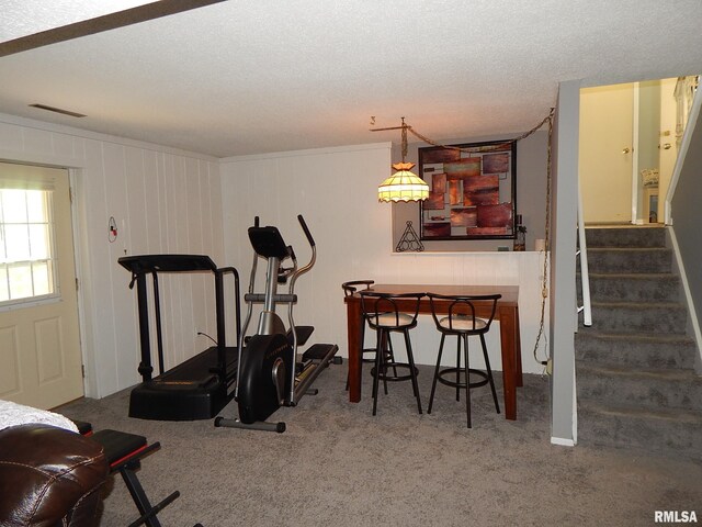 workout room with carpet flooring and a textured ceiling