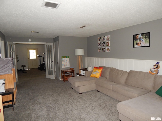 carpeted living area with a textured ceiling