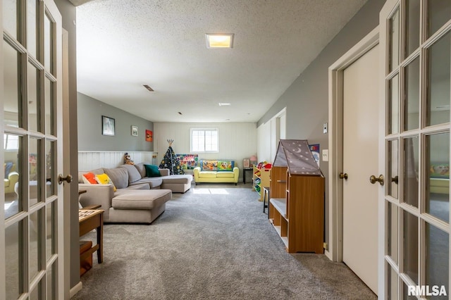 2885 Willow Dr, Bettendorf, IA 52722 - living area with french doors, carpet, wainscoting, and a textured ceiling
