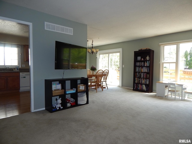 sitting room featuring carpet floors, a chandelier, healthy amount of natural light, and baseboards