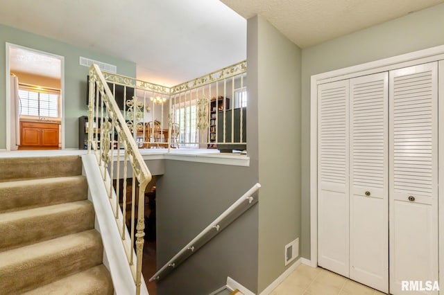 2885 Willow Dr, Bettendorf, IA 52722 - stairway featuring baseboards, a chandelier, and tile patterned flooring