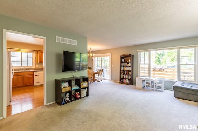2885 Willow Dr, Bettendorf, IA 52722 - living room featuring light carpet, a textured ceiling, a chandelier, and baseboards