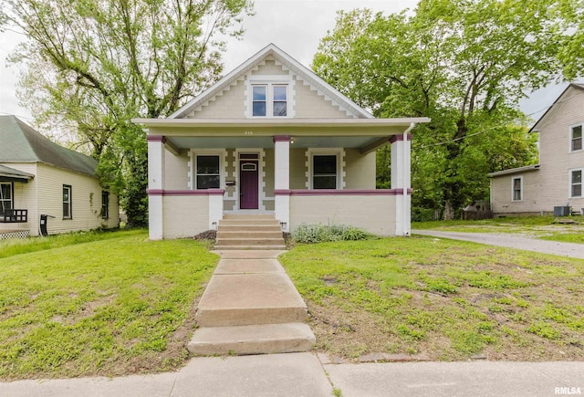bungalow-style house with a porch, a front yard, and central AC unit