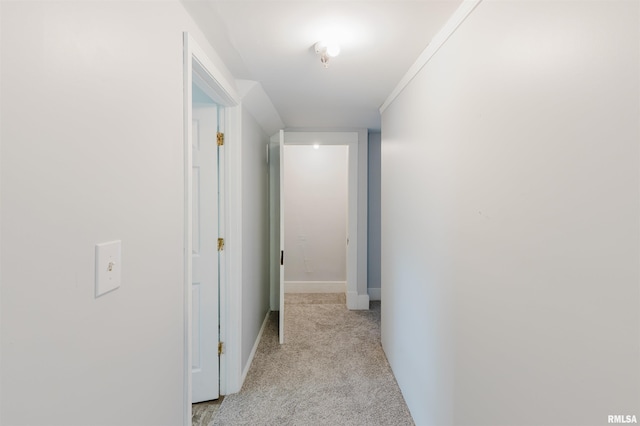 hall with light colored carpet and baseboards
