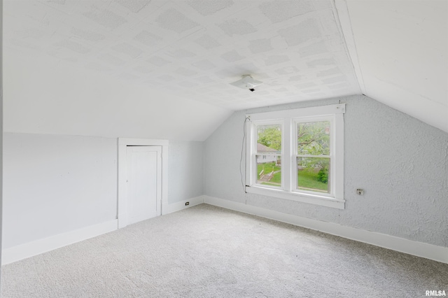 bonus room featuring lofted ceiling, baseboards, and carpet floors