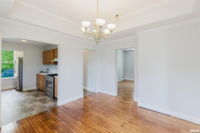 kitchen featuring appliances with stainless steel finishes, a chandelier, light wood-style flooring, ornamental molding, and light countertops