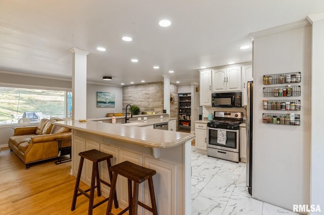 1 Kenwood Ave, Davenport, IA 52803 - kitchen featuring appliances with stainless steel finishes, a sink, ornamental molding, ornate columns, and recessed lighting