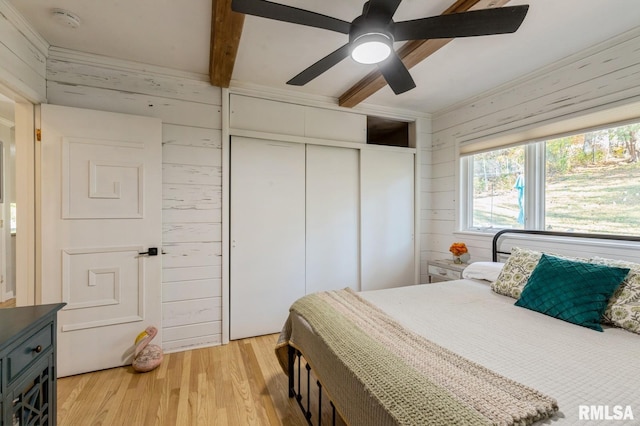 1 Kenwood Ave, Davenport, IA 52803 - bedroom with wooden walls, a closet, light wood-style flooring, and ceiling fan
