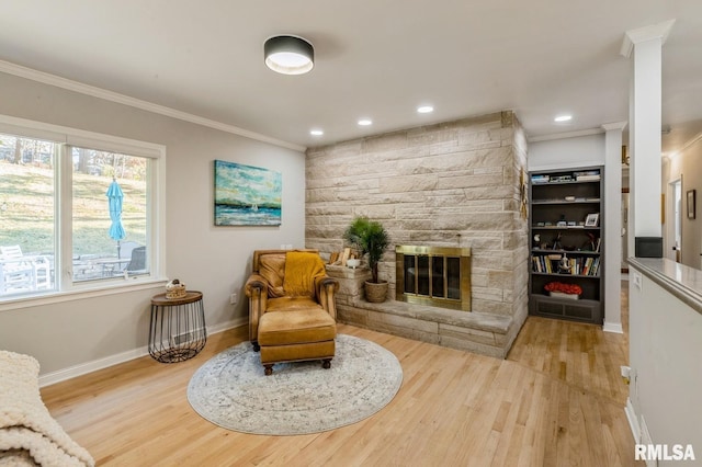 1 Kenwood Ave, Davenport, IA 52803 - sitting room with crown molding, wood finished floors, baseboards, a stone fireplace, and recessed lighting