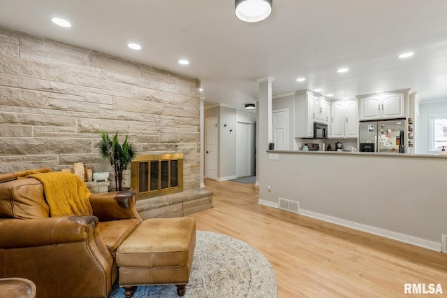 1 Kenwood Ave, Davenport, IA 52803 - living room with light wood-type flooring, baseboards, recessed lighting, a fireplace, and crown molding