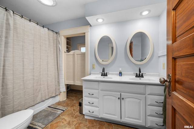 2307 N Ripley St, Davenport, IA 52803 - bathroom with toilet, double vanity, stone finish floors, and shower / bath combo with shower curtain