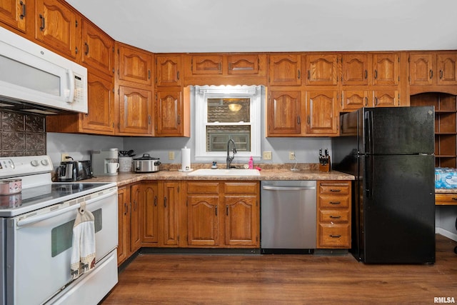 2307 N Ripley St, Davenport, IA 52803 - kitchen with white appliances, a sink, brown cabinetry, and dark wood-type flooring