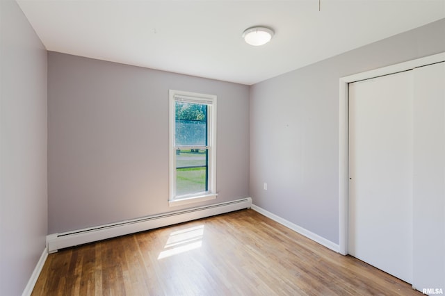 602 Barr St, Carterville, IL 62918 - unfurnished bedroom featuring a baseboard heating unit, wood finished floors, baseboards, and a closet