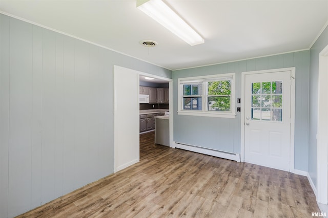 602 Barr St, Carterville, IL 62918 - kitchen with a baseboard heating unit, ornamental molding, white microwave, light wood-style floors, and light countertops