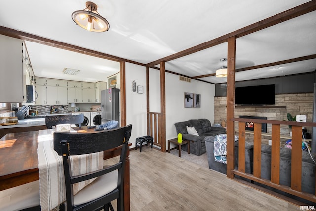 dining area featuring washing machine and clothes dryer and light wood-style flooring