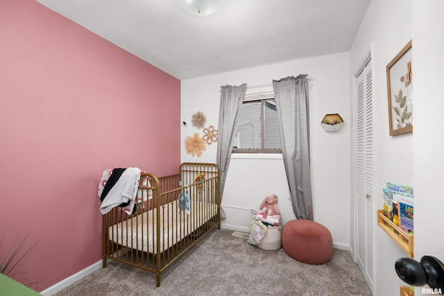 carpeted bedroom with a nursery area, baseboards, and a closet