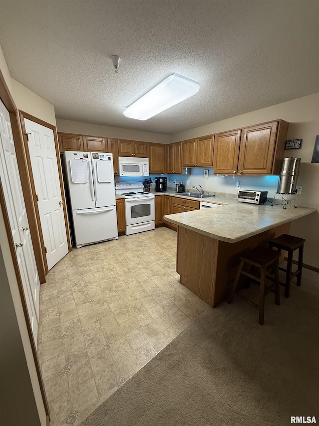 3205 S 16th Ave Unit 203, Eldridge, IA 52748 - kitchen with white appliances, a peninsula, brown cabinetry, light countertops, and a textured ceiling