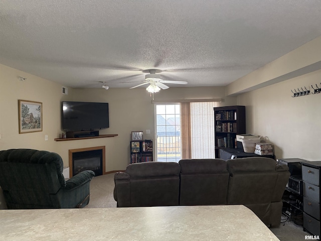 3205 S 16th Ave Unit 203, Eldridge, IA 52748 - carpeted living area featuring ceiling fan, a glass covered fireplace, and a textured ceiling