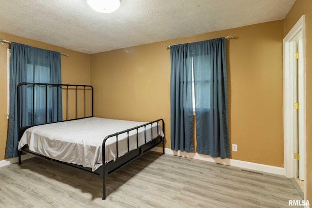 1401 Thomas St, Carterville, IL 62918 - bedroom with wood finished floors, baseboards, and a textured ceiling