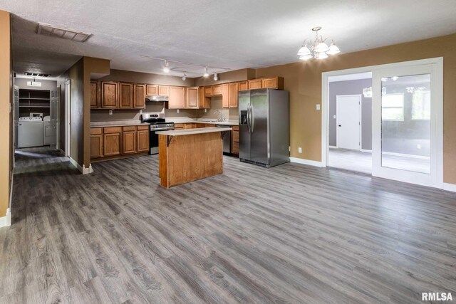 1401 Thomas St, Carterville, IL 62918 - kitchen with stainless steel appliances, under cabinet range hood, washer and clothes dryer, a kitchen island, and light countertops