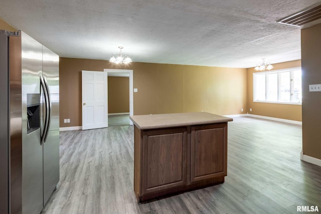 1401 Thomas St, Carterville, IL 62918 - kitchen with stainless steel fridge, a chandelier, light wood-style flooring, and a textured ceiling