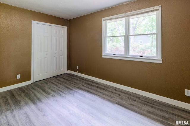 1401 Thomas St, Carterville, IL 62918 - unfurnished bedroom featuring wood finished floors, baseboards, a textured wall, and a closet