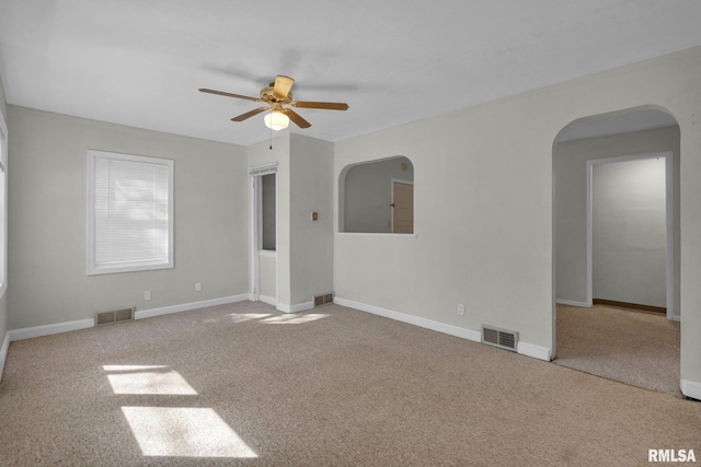 2910 Central Ave, Bettendorf, IA 52722 - spare room featuring arched walkways, a ceiling fan, carpet, and baseboards