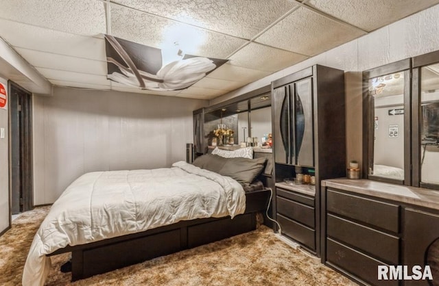 bedroom with light carpet and a drop ceiling