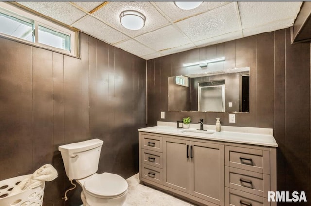 bathroom featuring a paneled ceiling, toilet, and vanity